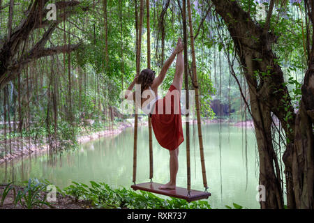 Tam Coc, Nimbin, Vietnam, September 2018. Junge Backpacker aus Spanien übt Yoga durch das Wasser auf einem nebligen Tag. Stockfoto