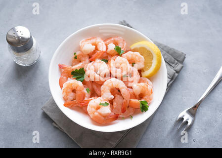 Garnelen in der Schüssel. Frische Meeresfrüchte - Garnelen Schwänze mit Zitrone. Gekochte Garnelen. Stockfoto