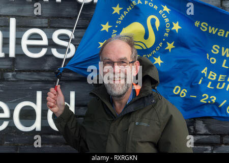 Cardiff, Wales, UK. 10. März 2019. Edmund Seiten setzt sich aus der Senedd Gebäude in Cardiff Bay auf der Cardiff Newport Bein seines entfernt. Er ist zu Fuß von Swansea nach London der Abstimmung März am 23. März. Einstellung von Swansea am Mittwoch, 6. März, Ed Ziele in London am 22. März, in der Zeit andere Swansea für Europa Mitkämpfer, die unter der Flagge für Swansea an der Abstimmung März sein zu verbinden. Die im März letzten Jahres, im Oktober, war eine der größten in der britischen Geschichte, Zeichnung 700.000 Menschen. Credit: Polly Thomas/Alamy leben Nachrichten Stockfoto