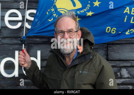 Cardiff, Wales, UK. 10. März 2019. Edmund Seiten setzt sich aus der Senedd Gebäude in Cardiff Bay auf der Cardiff Newport Bein seines entfernt. Er ist zu Fuß von Swansea nach London der Abstimmung März am 23. März. Einstellung von Swansea am Mittwoch, 6. März, Ed Ziele in London am 22. März, in der Zeit andere Swansea für Europa Mitkämpfer, die unter der Flagge für Swansea an der Abstimmung März sein zu verbinden. Die im März letzten Jahres, im Oktober, war eine der größten in der britischen Geschichte, Zeichnung 700.000 Menschen. Credit: Polly Thomas/Alamy leben Nachrichten Stockfoto