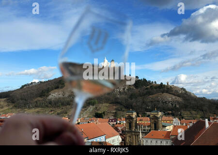Mikulov, Tschechische Republik. 9 Mär, 2019. Eine niedrige Winkel Blick durch ein Glas Wein am Heiligen Berg (ursprünglich Tanzberg Hügel) ist eine der landmarksof Mikulov, die nicht übersehen werden. Der Grundstein wurde am 2. Juli 1623 geweiht. Ein Kreuzweg aus sieben Kapellen wurde auch auf den Heiligen Berg zu der Zeit etabliert. Die Stadt Mikulov ist Teil der historischen Region Mähren, direkt an der Grenze zu Niederösterreich. Mikulov liegt zwischen dem Pavlovske vrchy hügeligen Gegend und dem Rand des Mikulov Hochland, Stretching bis zur Thaya und die drei Nove Mly gelegen Stockfoto