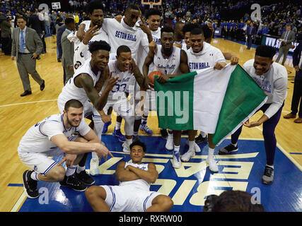 Newark, New Jersey, USA. 10 Mär, 2019. Seton Hall Piraten Mannschaftskameraden feiern Sie mit älteren vorwärts Michael Nzei (1) mit Nigeria Flagge Nachdem die Villanova Wildcats 79-75 im Prudential Center in Newark, New Jersey. Duncan Williams/CSM/Alamy leben Nachrichten Stockfoto