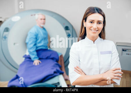 Porträt Lächeln Arzt, an den medizinischen Zimmer mit CT ständigen Scan Stockfoto