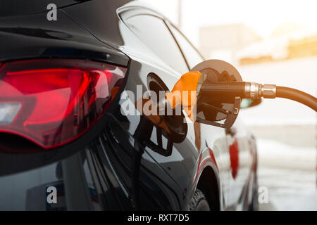 Schwarz neu Auto tankt an der Tankstelle. Gewehr im Gas-tank. Stockfoto