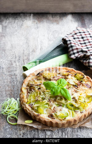 Tarte mit Speck und Käse auf dem Holztisch Stockfoto