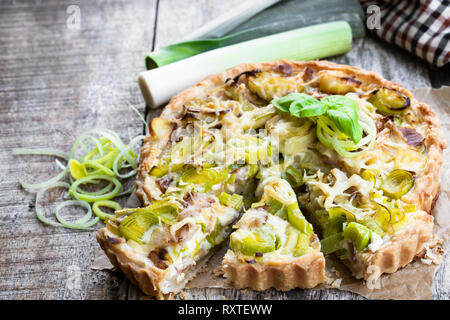 Tarte mit Speck und Käse auf dem Holztisch Stockfoto