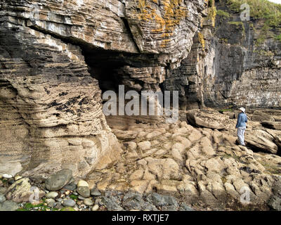 Weibliche Touristen erodierten Felsen, Klippen und Grotten am Ufer in der Nähe von Elgol auf der schottischen Insel Skye, Schottland, UK suchen Stockfoto