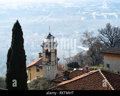 Reisen nach Italien - Oben anzeigen Glockenturm der Kirche chiesetta di San Vigilio und die Vororte von Bergamo Stadt von San Vigilio Castel im Frühjahr Haze Stockfoto