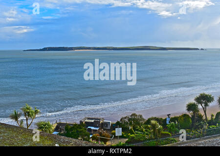 Der Blick über das Wasser von der Esplanade im Resort von Tenby, Caldey Island, die Heimat der Zisterziensermönche, die noch Caldey Abtei belegen. Stockfoto