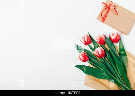 Ansicht von oben Bouquet von schönen roten Tulpen in braunem Papier und Karton auf weißem Hintergrund Holz, kopieren. Stockfoto