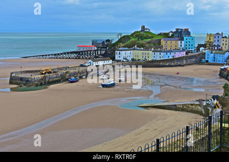 Der hübsche Hafen von Tenby, Ebbe im Winter. Rettungsstationen alt & neu mit pastellfarbenen Häuser mit Blick auf den Sandstrand von North Beach. S. Wales Stockfoto