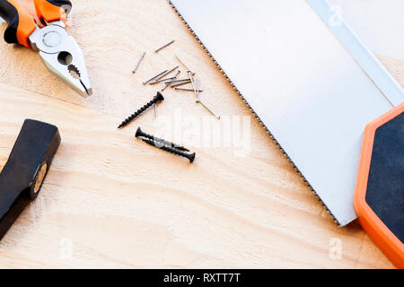 Hammer, Nägel und Zange liegen auf einem Holz- Hintergrund. Construction Tools selektiven Fokus Stockfoto