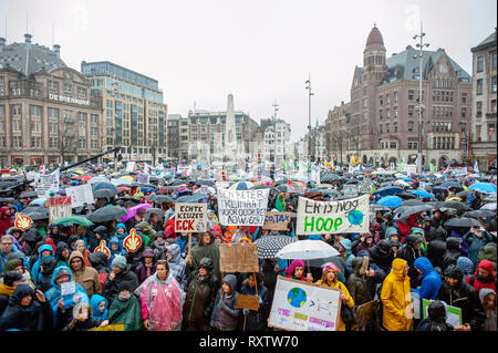 Tausende von Menschen werden gesehen, Plakate unter der Regen während der März. Die größte Klima Streik in den Niederlanden. Diese Demonstration fand auf dem Dam Platz, im Zentrum von Amsterdam. Tausende von Menschen versammelt, grüne Energie für jedermann erschwinglich zu verlangen, großen Verschmutzer haben ihren angemessenen Anteil zu zahlen, sollte eine gerechte Verteilung von Kosten und Nutzen der Klima wandel und gute grüne Arbeitsplätze. Stockfoto