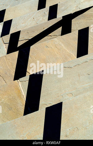 Schatten von Geländer, die von Sun auf der Steinplatte Schritte cast Stockfoto