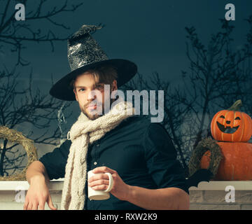 Halloween macho Holding Schale am Fenster mit Bäume im Herbst Stockfoto