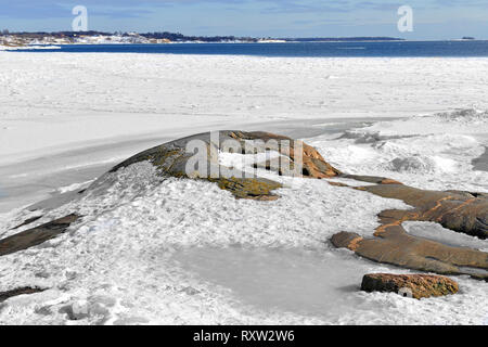 An der felsigen Küste der verschneiten Insel des Archipels in Helsinki, Finnland. Feder Stockfoto