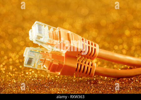 Zwei Netzwerkkabel über orange funkelt Hintergrund Stockfoto
