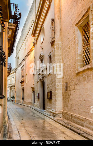 Mdina, Malta: gepflasterte Gasse mit Pflastersteine mit Kalksteinwänden. Mittelalterliche maltesische Architektur Stockfoto