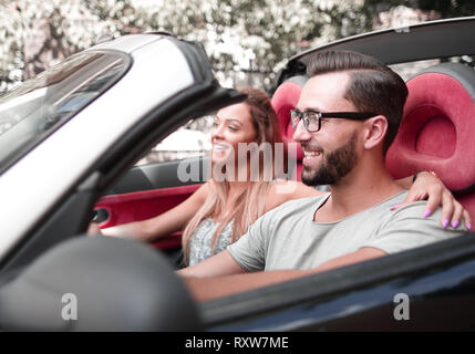 Liebespaar auf dem Vordersitz eines Cabrio Auto sitzen Stockfoto