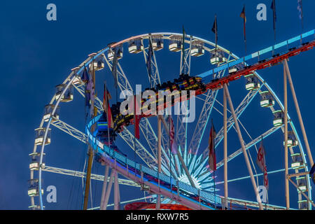 Amusement Park bei Nacht - Riesenrad und Achterbahn in Bewegung Stockfoto