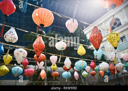 Vielen bunten Lampions hängen an den Kabeln auf dem Gebäude im Hintergrund. Es ist die Feier des chinesischen Neujahrsfest in Nha Trang, Vietnam. Stockfoto