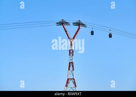 Bunte Seilbahn mit bewegten bunten Kabinen auf den sonnigen blauen Himmel Hintergrund in Nha Trang, Vietnam. Horizontale. Stockfoto