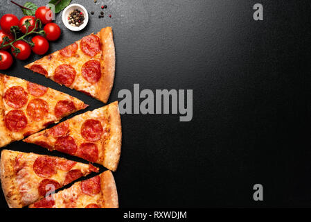 Pepperoni Pizza Slices auf schwarzen Hintergrund. Blick von oben auf die Pizza. Kopieren Sie Platz für Text, Menü, Rezept Stockfoto