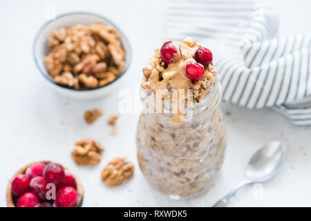 Über Nacht Hafer mit Beeren und Erdnussbutter. Trendy gesundes Frühstück essen, vegane Mahlzeit Stockfoto