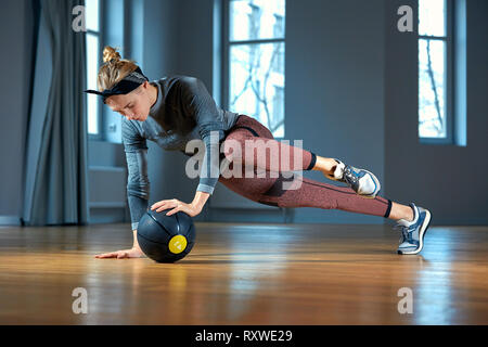 Fit und muskulöse Frau, intensive Core Training mit kettlebell in der Turnhalle. Weibliche ausüben, crossfit Fitnessraum. Stockfoto