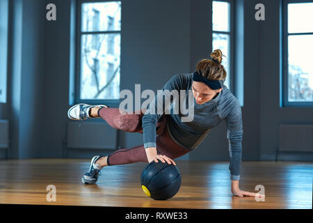 Fit und muskulöse Frau, intensive Core Training mit kettlebell in der Turnhalle. Weibliche ausüben, crossfit Fitnessraum. Stockfoto