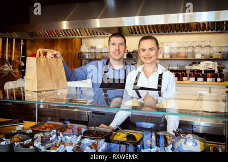 Catering Services mit Kellner hinter der Theke serviert Essen zum Mitnehmen Stockfoto