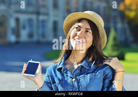 Ein junges Mädchen der asiatischen Aussehen genießt das Leben und hört Musik den Kopf heben und Lächeln Stockfoto