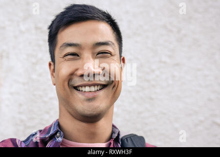 Glückliche junge asiatischer Mann einen selfie in der Stadt Stockfoto