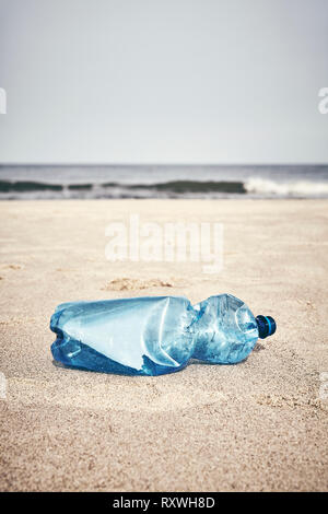 Leere Plastikflasche an einem Strand, selektiver Fokus, Farbe Tonen angewendet. Stockfoto