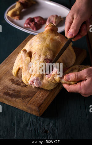 Ein Mann schneidet ein Huhn in Stücke Stockfoto