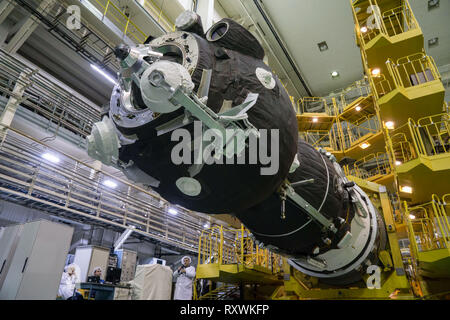 Die russische Sojus MS-12 Raumschiff in die richtige Stellung für die Einkapselung in der Nase Nutzlastverkleidung der Trägerrakete in der Integration Gebäude auf dem Kosmodrom Baikonur März 6, 2019 in Baikonur, Kasachstan abgesenkt. Die Expedition 59 Crew: Nick Haag und Christina Koch von NASA und Alexey Ovchinin von roskosmos wird gestartet 14. März für eine sechs-und-ein-halb Monat Mission auf der Internationalen Raumstation. Stockfoto