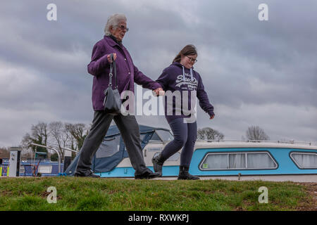 Junges Mädchen mit Down-syndrom mit ihrer Großmutter zu Fuß an den Weißen Mühlen Marina, Earls Barton, Northamptonshire, Großbritannien. Stockfoto