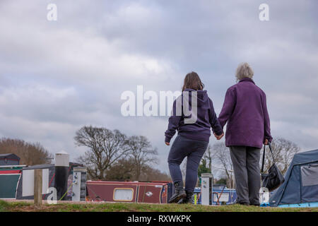 Junges Mädchen mit Down-syndrom mit ihrer Großmutter zu Fuß an den Weißen Mühlen Marina, Earls Barton, Northamptonshire, Großbritannien. Stockfoto