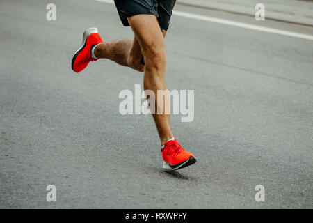 Beine mann Runner in hellen roten Schuhen laufen auf Asphalt Stockfoto