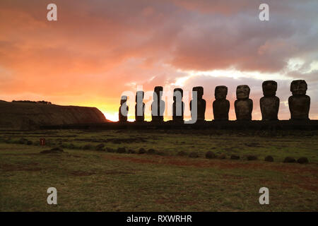 Silhouette von neun der 15 riesigen Moai Statuen am Ahu Tongariki gegen die Farbe orange sunrise Himmel, archäologischen Stätte in der Osterinsel, Chile Stockfoto