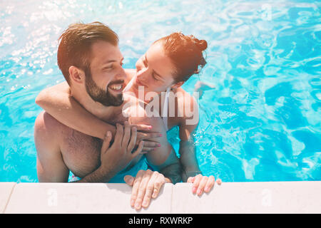 Fröhliche junge Mann und Frau ruht, Schwimmbad Outdoor. Paar in Wasser Stockfoto