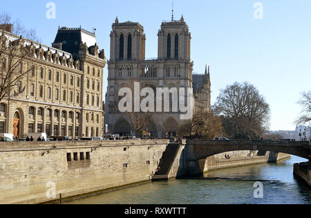 PARIS, Frankreich, 24. Februar 2019: Die Kathedrale von Notre-Dame und die Brücke, den Pont des coueurs, von der Seine mit der Präfektur de Police, P Stockfoto