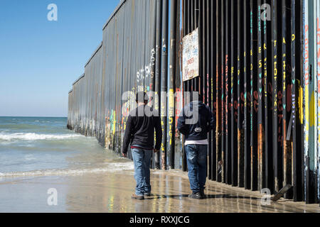 Zwei Männer satanding in Tijuana Strand, auf der anderen Seite der Mexikanischen Grenze. Stockfoto