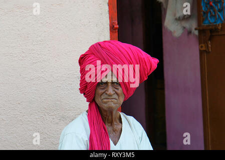 Eine alte Dorfbewohner mit Turban der traditionellen Stil sitzen vor seinem Haus am Palashi, Parner, Ahmednagar. Stockfoto