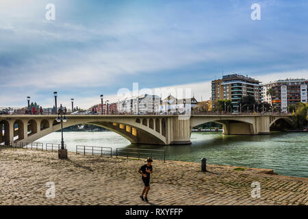 Sevilla, Spanien-Dez 2018: ein Mann joggen Canal Alfonso XII nach San Telmo Brücke Stockfoto