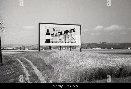 1930, in der Tschechoslowakei, historische Bild aus dieser Ära der großen Anzeigentafel oder die Werbung für "Schwarz und Weiß" Scotch Whisky in einem Feld neben Neue des Landes Autostradu oder Autobahn. Stockfoto