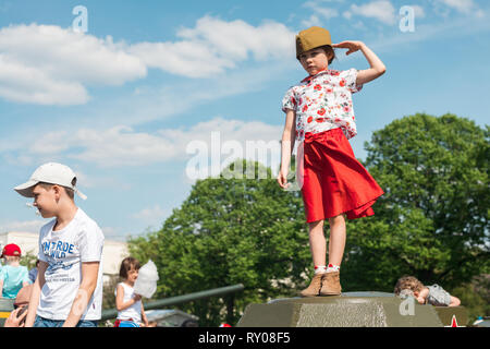 Moskau, Russland - Mai 9, 2016. Kleines Mädchen in einem roten Rock und Futter - Gap steht auf einem Panzer des Zweiten Weltkriegs und begrüßt während Sieg Stockfoto