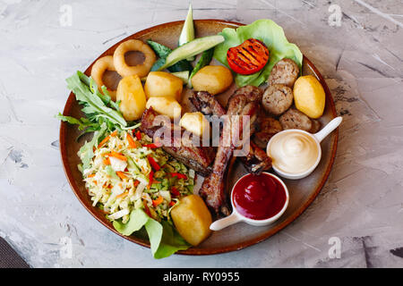 Köstliche Vorspeisen restaurahnt für Bier eingestellt. Ketchup und Mayo Festlegung auf Lehm Platte. Stockfoto