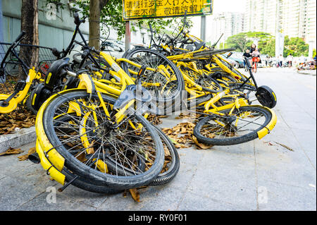 Stapel der Ofo Gemeinschafts-bikes entleert auf Pfad in Shenzhen, China Stockfoto