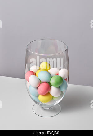 Bunt bemalte Eier in einem Glas Vase auf einem grauen Hintergrund mit Platz für Text. Ostern Konzept Stockfoto